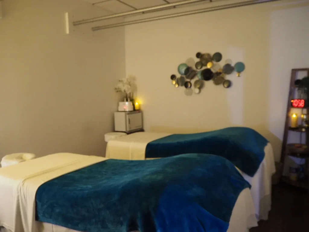 Couples room with two massage tables side by side under metal disc wall art
