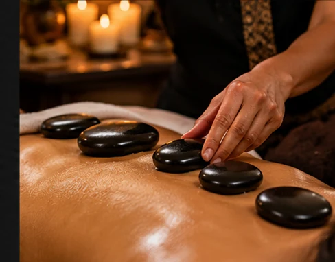 Smooth black massage stones placed along a client's back during a relaxing hot stone massage treatment.